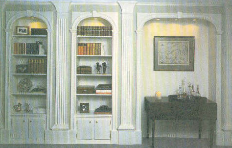 Painted built-in bookcases with arched tops and fluted pilasters
