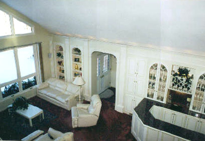 Living room with painted built-in shelving and a fitted bar cabinet